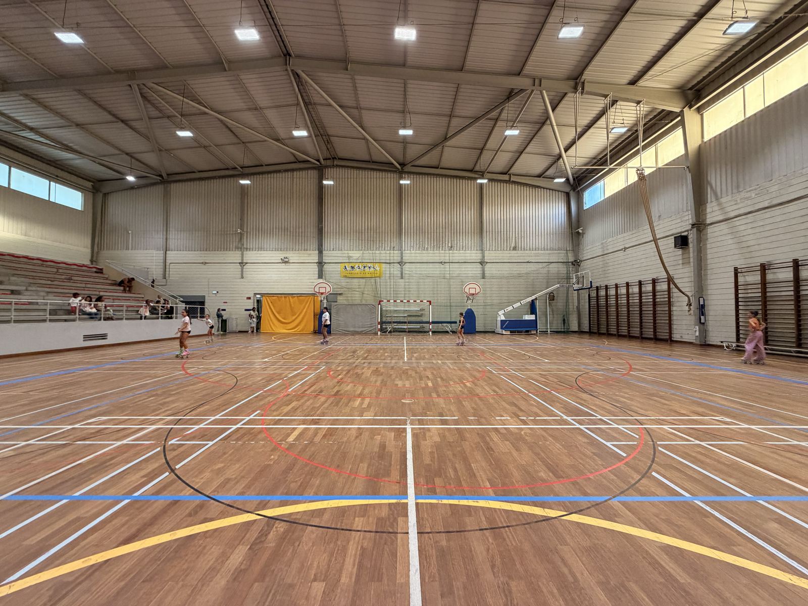 Bancada do pavilhão, com acompanhantes a assistir ao treino